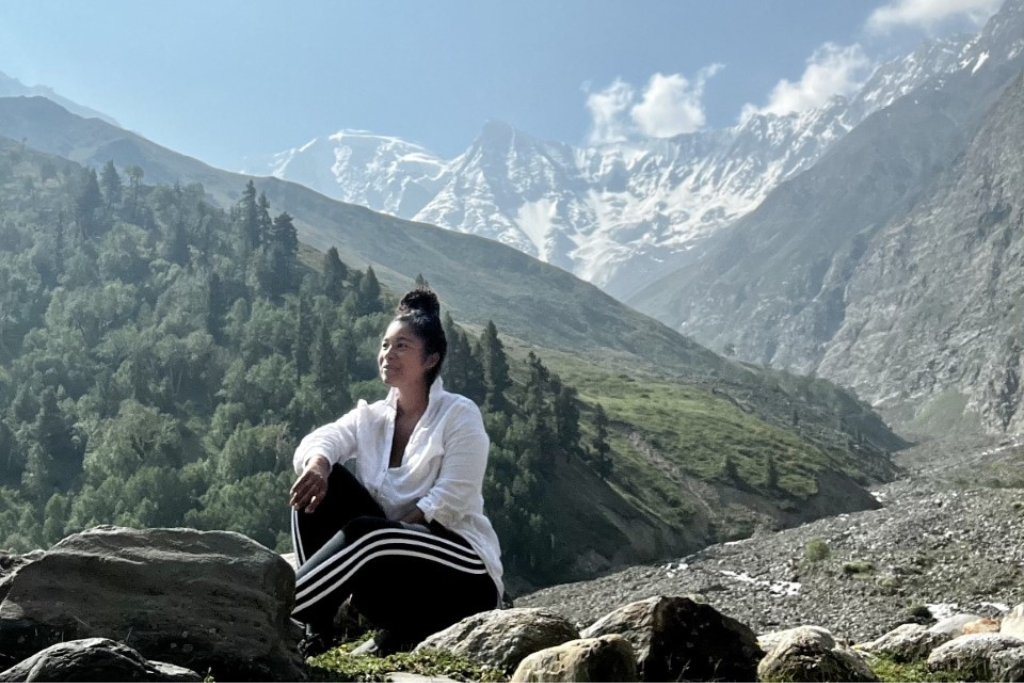 Tatjana Washington sitting on a mountainside with mountains in background
