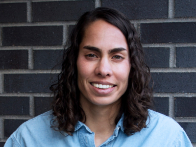 Sheela P. Turbek, Ph.D. in front of brick wall.