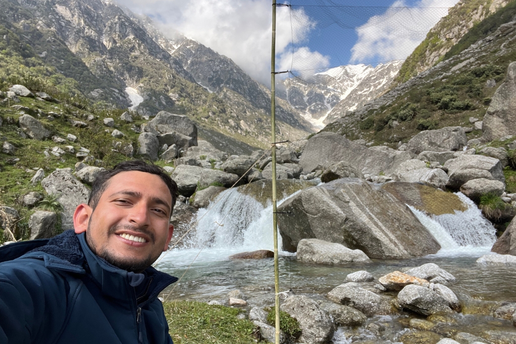 Prashant Ghimire setting up a mist net against the stunning backdrop of the Himalayas in Himachal Pradesh, India.